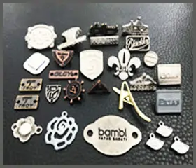 Düğme, perçin ve marka logolu metal aksesuarlar.